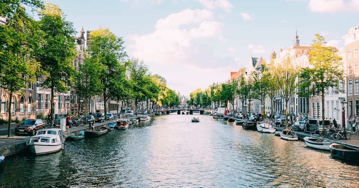 Amsterdamse grachten met moderne kantoorpanden en website op laptop